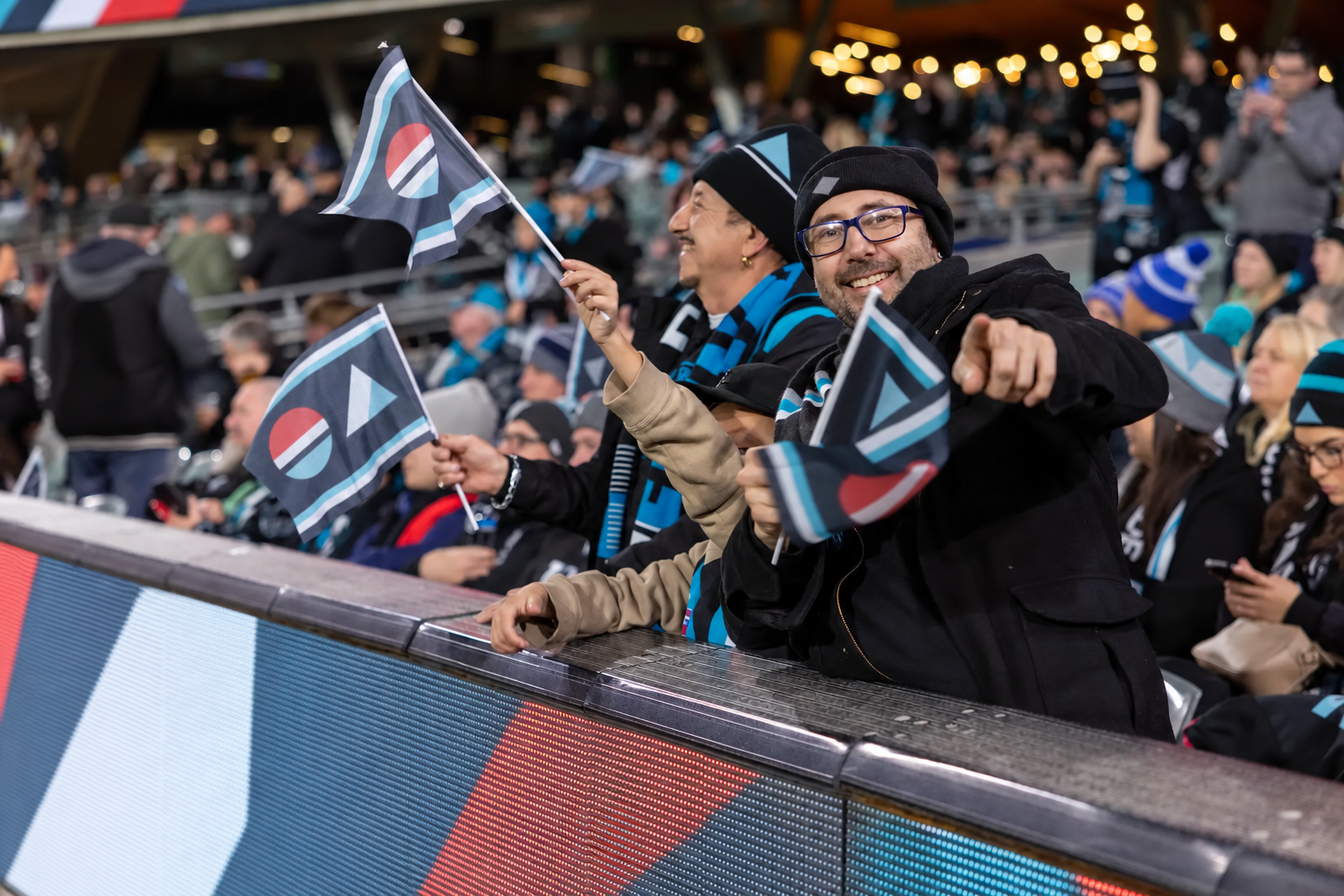 Event supporter waving a custom flag at an outdoor sporting event